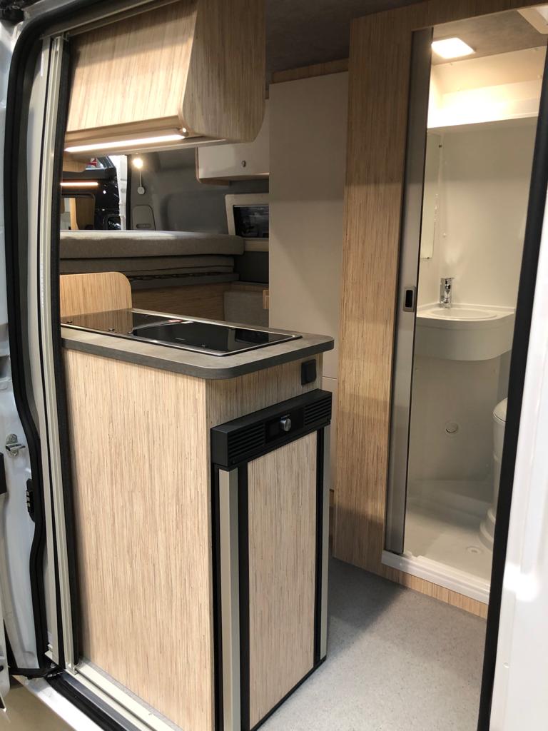 Pössl Kastenwagen, Küche mit robuster Oberfläche der Arbeitsfläche, Kühlschrank mit Frostfach